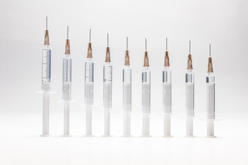 syringes with needles lined up in a row show a graph of ever fewer vaccinations