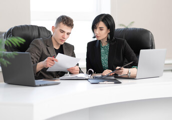 Businessman and businesswoman meeting in modern office working on laptop, business meeting