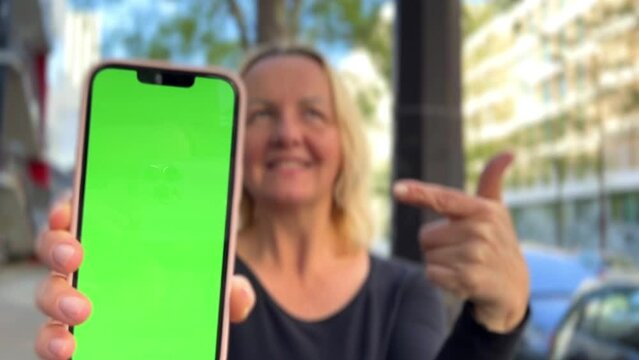 Woman 35-45 with loose hair brown hair brown hair dances with phone rejoices on the screen of lameness green screen beige background. High quality 4k footage