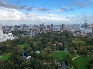 Obraz premium Aerial view of the city of Rotterdam in autumn, its city center and its skyscrapers, the Het Park, on a slightly cloudy day