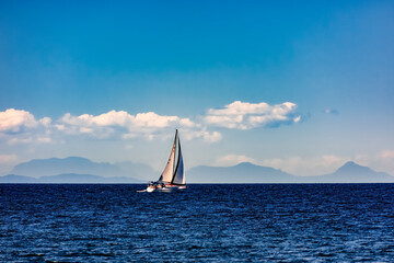sail boat with mountains and clouds