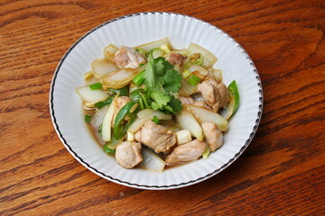 Stir-fried pork with chilli with onions and spring onions served in a white plate, Stir-fried pork with chilli is a popular Thai dish that Thai people eat.