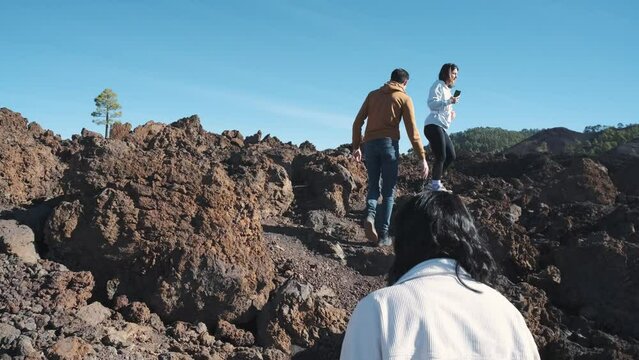 A group of tourists walk through the mountains of solidified lava in the Teide volcano National Park on the island of Tenerife