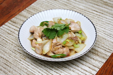 Stir-fried pork with chilli with onions and spring onions served in a white plate, Stir-fried pork with chilli is a popular Thai dish that Thai people eat.