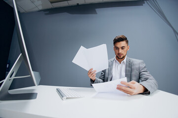 manager working at the computer in the office scatters documents executive