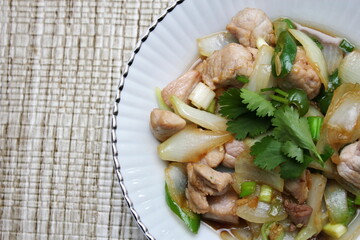 Stir-fried pork with chilli with onions and spring onions served in a white plate, Stir-fried pork with chilli is a popular Thai dish that Thai people eat.