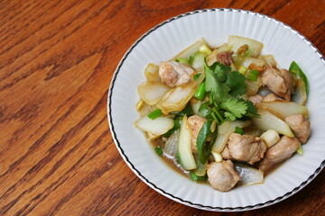 Stir-fried pork with chilli with onions and spring onions served in a white plate, Stir-fried pork with chilli is a popular Thai dish that Thai people eat.