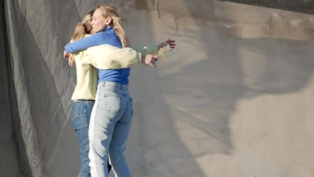 Two girls meeting after long time war, running into each other with open arms and hugging