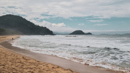 Beira do mar com morros ao fundo