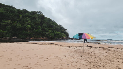 Fototapeta na wymiar Beira do mar e guarda chuva colorida