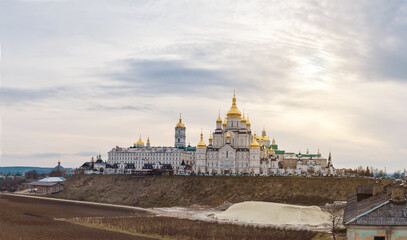 Obraz premium Majestic Orthodox religious building. Holy Dormition Pochaiv Lavra in Ukraine. Panoramic view. Cloudy sky background.