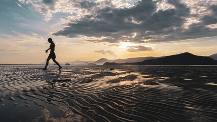 Fototapeta na wymiar Mulher fazendo exercícios físicos durante o pôr do sol na praia brasileira
