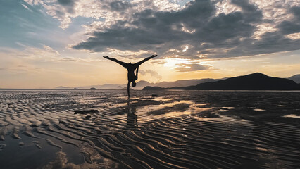 Mulher fazendo exercícios físicos durante o pôr do sol na praia brasileira