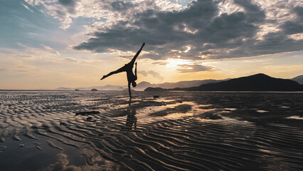 Mulher fazendo exercícios físicos durante o pôr do sol na praia brasileira