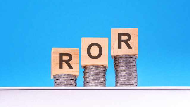 ror - text on wood cubes stack with coins
