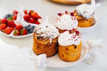 decorated panettones and cruffins on serving plates with rabbits. easter cakes. 