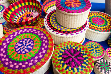 Wicker souvenirs baskets made from toquilla straw, vegetable fiber and painted with various colors at the artisan market in Cuenca, Ecuador