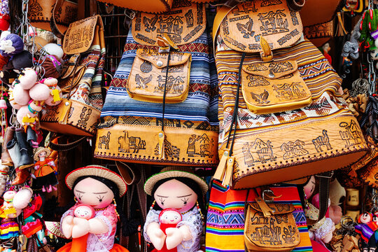 Colorful bags and backpacks made from cloth and leather, different souvenirs on the display at the artisan's market in Cuenca, Ecuador