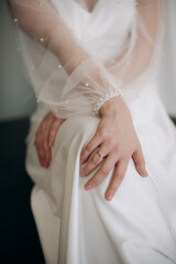Fototapeta na wymiar bride in a wedding dress gently touches the ring with her fingers