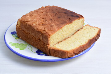 Fototapeta na wymiar Homemade vanilla cake, displayed on plate and wooden background