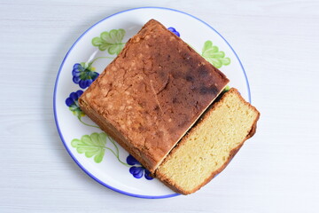 Homemade vanilla cake, displayed on plate and wooden background