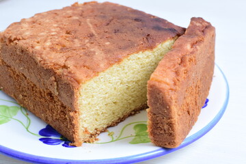 Homemade vanilla cake, displayed on plate and wooden background