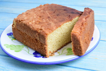 Homemade vanilla cake, displayed on plate and wooden background