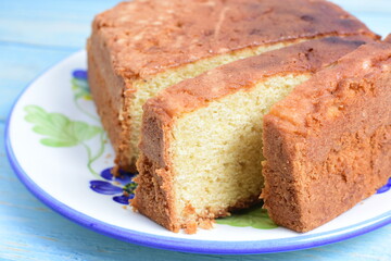 Homemade vanilla cake, displayed on plate and wooden background