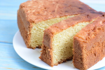 Homemade vanilla cake, displayed on plate and wooden background