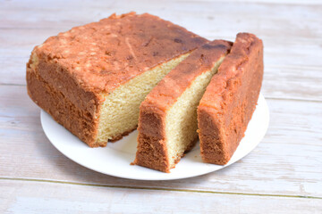 Homemade vanilla cake, displayed on plate and wooden background