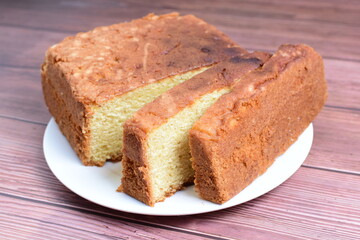 Homemade vanilla cake, displayed on plate and wooden background