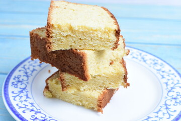 Homemade vanilla cake, displayed on a plate and portioned and on a wooden background