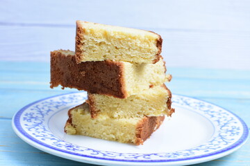Homemade vanilla cake, displayed on a plate and portioned and on a wooden background
