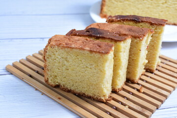 Homemade vanilla cake, displayed on a plate and portioned and on a wooden background