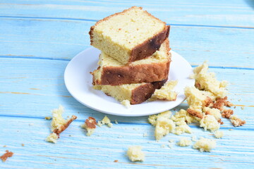 Homemade vanilla cake, displayed on a plate and portioned and on a wooden background