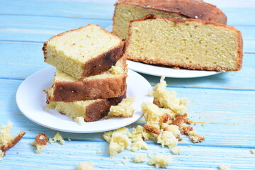 Homemade vanilla cake, displayed on a plate and portioned and on a wooden background
