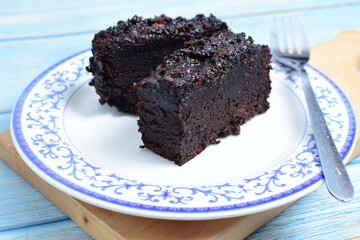 Traditional black ponque, with raisins, red wine flavor on wooden background