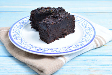 Traditional black ponque, with raisins, red wine flavor on wooden background