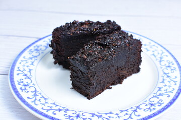 Traditional black ponque, with raisins, red wine flavor on wooden background