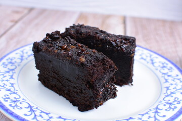 Traditional black ponque, with raisins, red wine flavor on wooden background