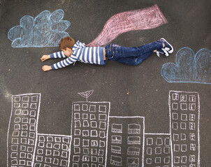 Whatever you can imagine.... Top view of a young boy using chalk and imagination to create his own...