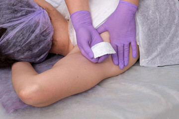 Obraz na płótnie Canvas Wax hair removal concept. Process depilation of underarm girl with white wax in spa salon.