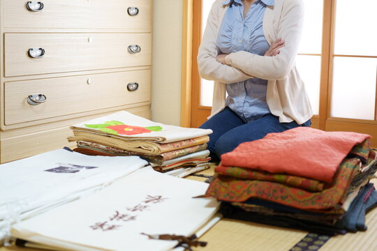 着物ダンスを整理しながら悩む中年女性　顔無し