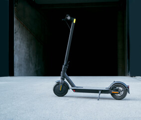 Modern clean e scooter in front garages in the city, dark grungy background  © phoenix021