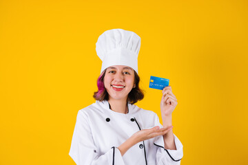 young Latin woman student chef holding credit card and copy space on yellow background in Mexico latin America	