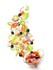 Bowl with flying ingredients of healthy Greek salad on white background