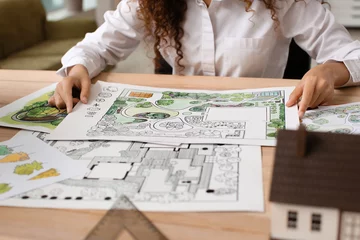 Abwaschbare Fototapete Lachsfarbe Junge weibliche Landschaftsarchitektin, die im Büro arbeitet