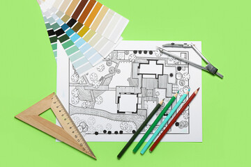 Landscape designer's plan with stationery and color samples on green background