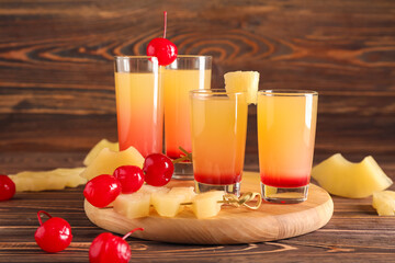 Board with tasty Pineapple Upside Down Cake Shots on wooden background