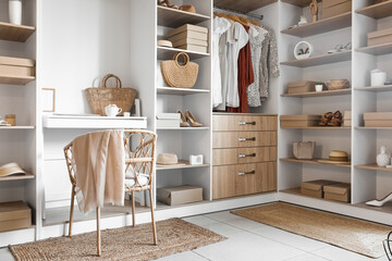 Interior of modern wardrobe with shelves and workplace